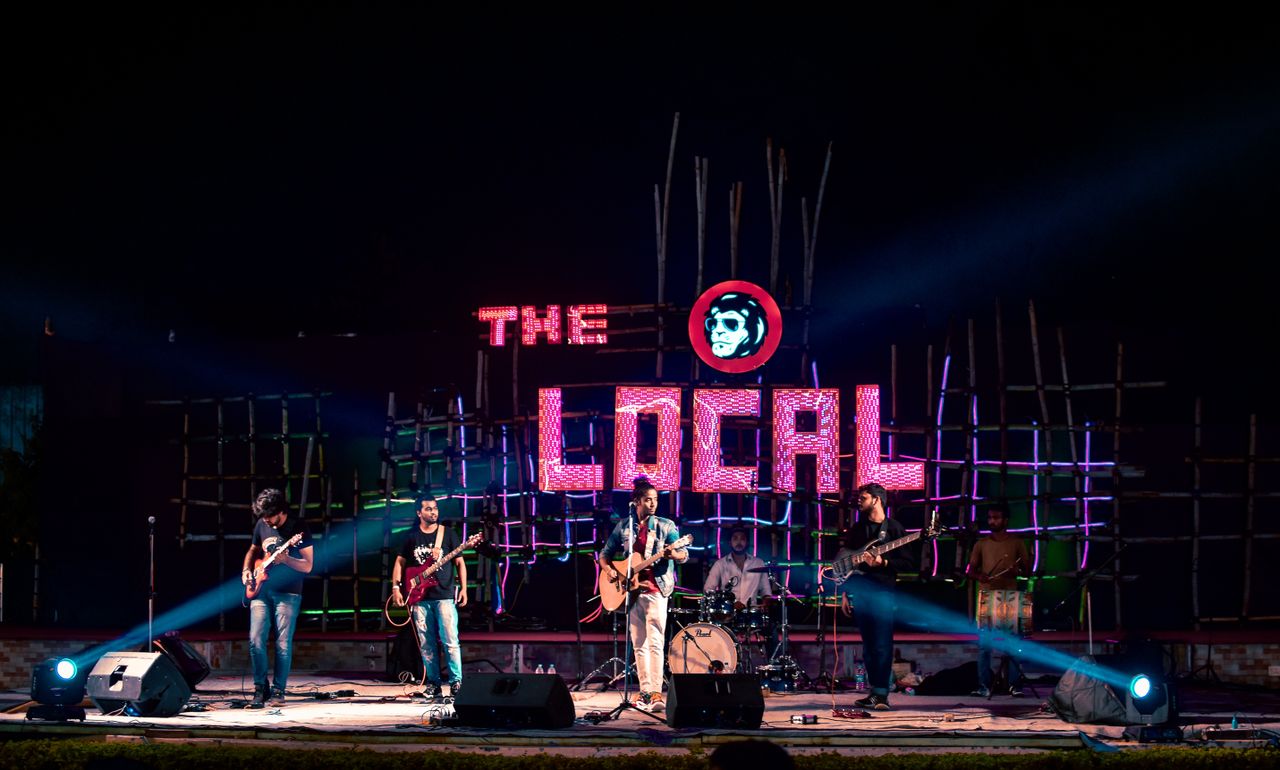 Energetic live music performance by a band on stage at The Local venue, Raipur.